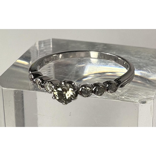 765 - An 18 carat hallmarked white gold ring set with a central clear stone, 23 small diamonds to each sho... 