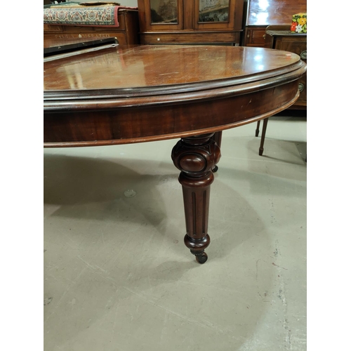 942 - A Victorian mahogany large wind-out dining table on turned flited legs, and castors, 3 spare leaves,... 