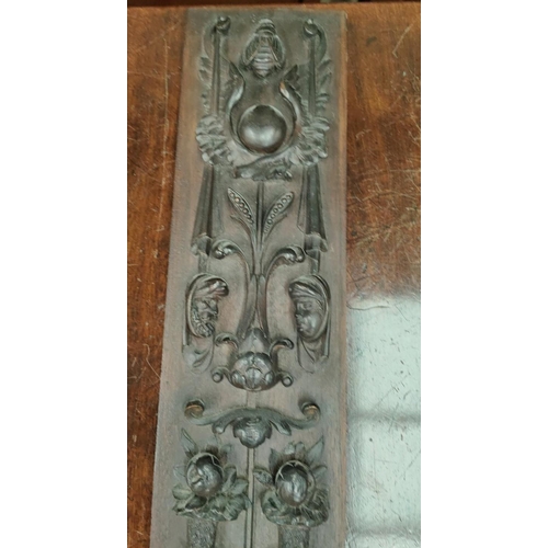 112A - A 19th century carved wooden wall hanging plaque with relief decoration of various heads, cornucopia... 