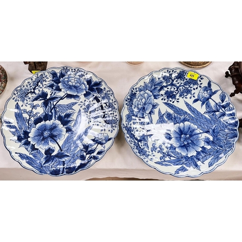 425 - A pair of Japanese blue and white scalloped edged chargers decorated with plants 39cm