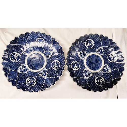 425A - A pair of blue and white oriental wall plaques with shaped boarders and plant decoration, dia 31cm