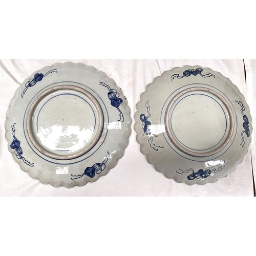 425A - A pair of blue and white oriental wall plaques with shaped boarders and plant decoration, dia 31cm