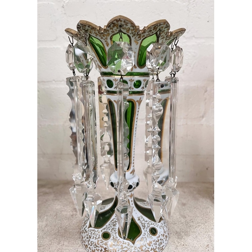 457B - A Victorian green glass lustre overlaid and cut back in opaque white with gilt decoration and facete... 