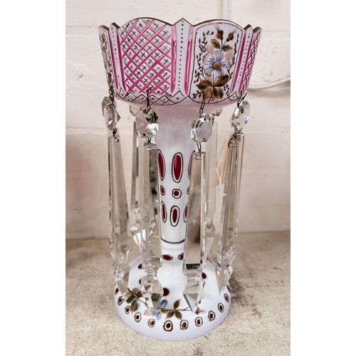 458A - A Victorian cranberry glass lustre, overlaid and cut back in opaque white with polychrome painted de... 