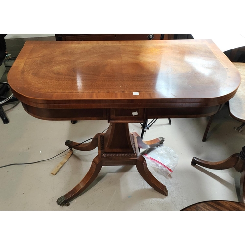 998 - A reproduction Regency XB mahogany fold over tea table on square top column, splay legs and brass ca... 