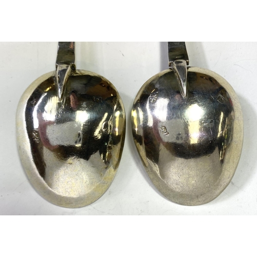 620 - A pair of continental white metal apostle top anointing spoons with monogrammed and gilded bowls.