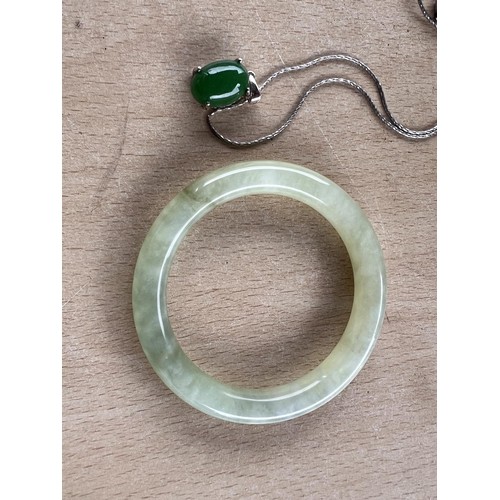 721 - A silver necklace with jade coloured hardstone cabochon; A Chinese Jade coloured hardstone bangle