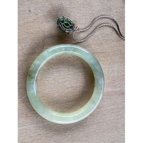 721 - A silver necklace with jade coloured hardstone cabochon; A Chinese Jade coloured hardstone bangle