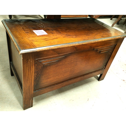 1066 - A 1930's oak blanket box with hinged lid and relief decoration to the front