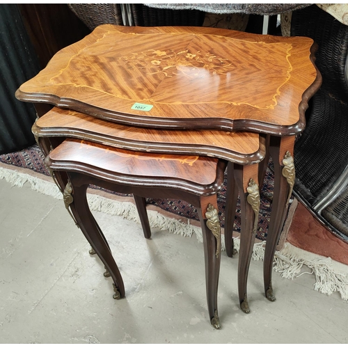 1057 - A nest of three Italian style marquetry inlaid occasional tables