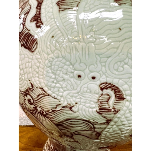 414 - A large Chinese inverted baluster vase with red wave decoration with dragons in relief between the w... 