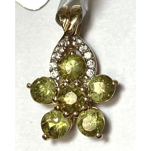 723 - A flower head pendant set with green stones; a pendant set with a light blue oval stone, both stampe... 