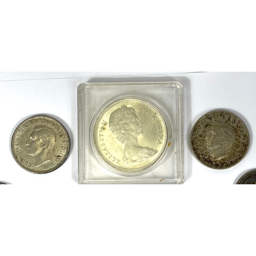 204 - A selection of foreign silver coins including a 1965 Canada dollar