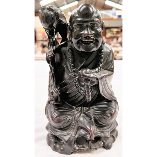 359 - A Chinese hardwood carved depiction of seated Buddha with scholars brush height 27cm