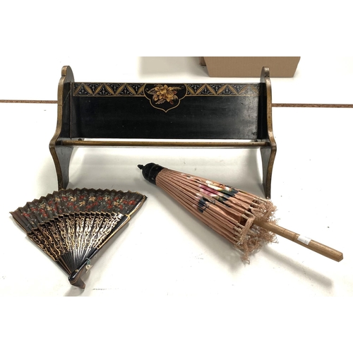 36 - An oriental lacquered bookrack; an oriental parasol and fan