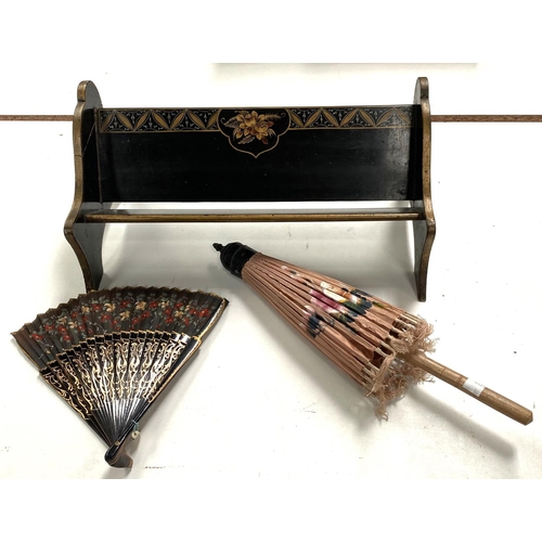 36 - An oriental lacquered bookrack; an oriental parasol and fan