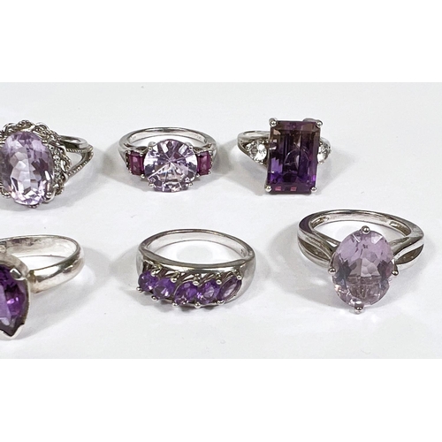 621 - Eight silver rings in a variety of designs, each set with 1 or more amethyst coloured stones, 39.4gm