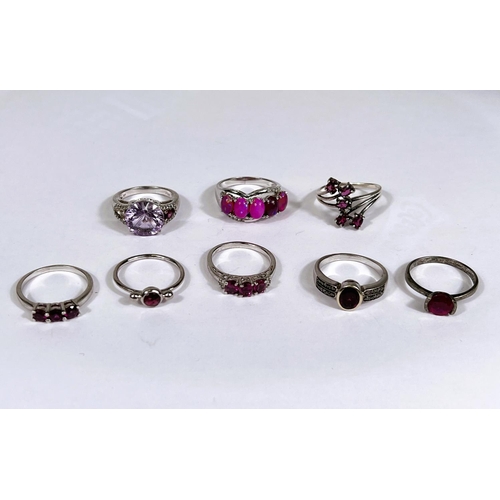 627 - Eight silver rings in a variety of settings, each with pink/ amethyst coloured stones, 26.9gm