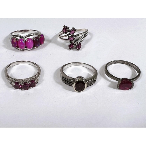 627 - Eight silver rings in a variety of settings, each with pink/ amethyst coloured stones, 26.9gm