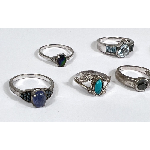 632 - Eight silver rings in a variety of designs, set blue tone stones, 21.5gm