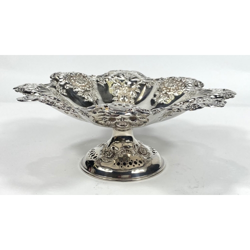 696 - A hallmarked silver shallow pedestal dish of circular scalloped form with extensive pierced and embo... 