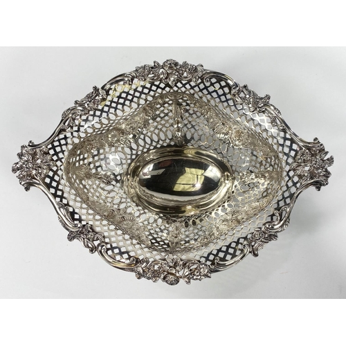 697 - An elongated oval bowl on pedestal with scroll and flower border, extensively pierced body with flor... 