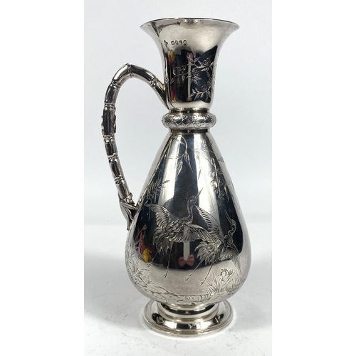 700 - A hallmarked silver wine jug of tapering baluster form and cane effect handle, chased with herons an...