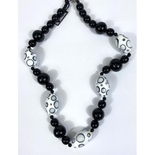 716 - VENICE STYLE, a glass bead necklace in black and white with silver clasp, 64cm; a polished bead neck... 