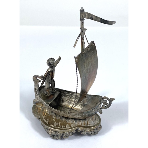 724 - A hallmarked silver model:  man in a single masted boat, import marks for Chester 1891, height ... 