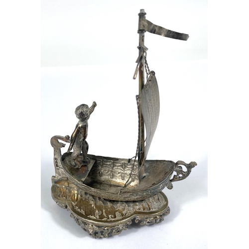 724 - A hallmarked silver model:  man in a single masted boat, import marks for Chester 1891, height ... 