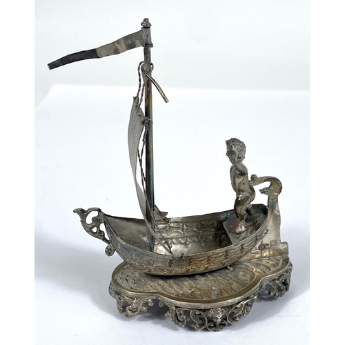 724 - A hallmarked silver model:  man in a single masted boat, import marks for Chester 1891, height ... 