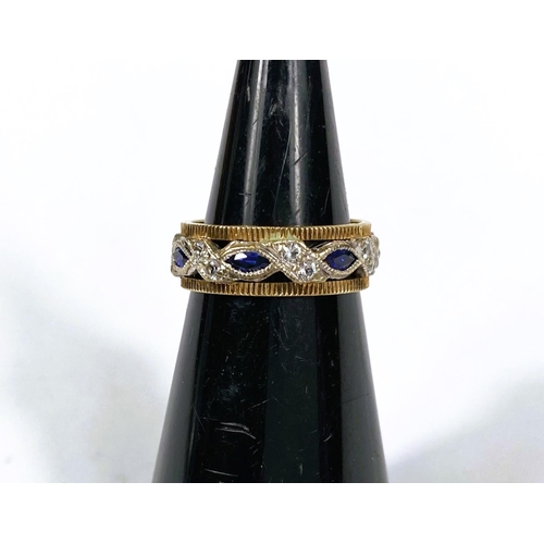 732 - A two tone yellow and white metal dress ring set with blue and white sapphires, 3.6gms, size K