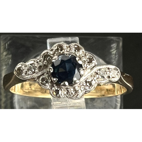 751 - An 18ct hallmarked gold ring with central sapphire and small diamonds in crossover form