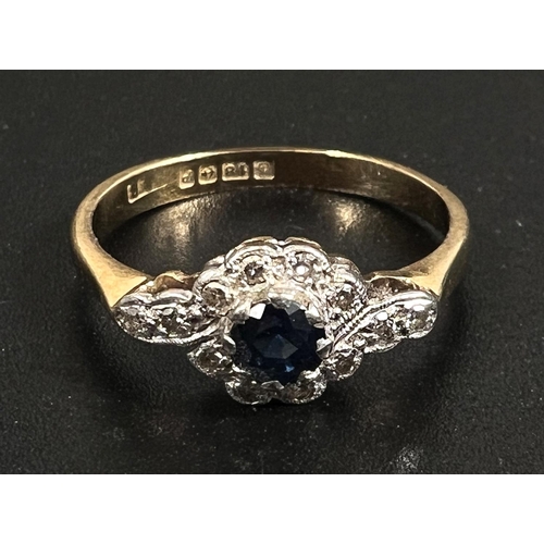 751 - An 18ct hallmarked gold ring with central sapphire and small diamonds in crossover form