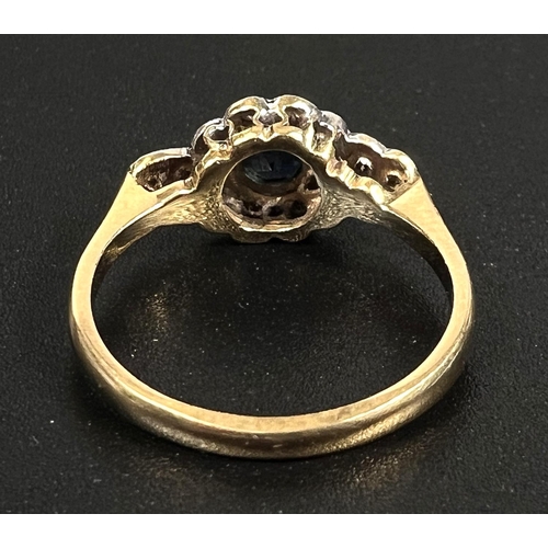 751 - An 18ct hallmarked gold ring with central sapphire and small diamonds in crossover form