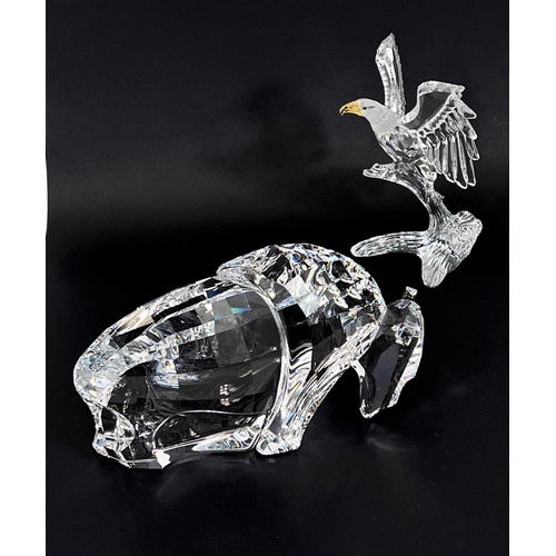 504 - A Swarovski crystal figure of a bison, length 16cm; a Swarovski crystal eagle perched on a... 