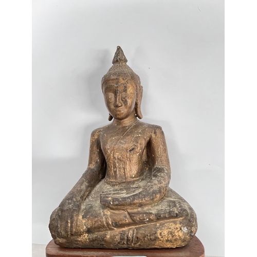 376 - A South East Asian carved wooden seated Buddha decorated in gilt with wooden base height 20cm 