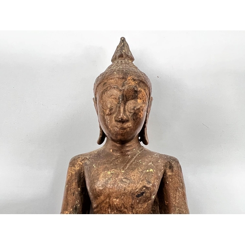 376 - A South East Asian carved wooden seated Buddha decorated in gilt with wooden base height 20cm 