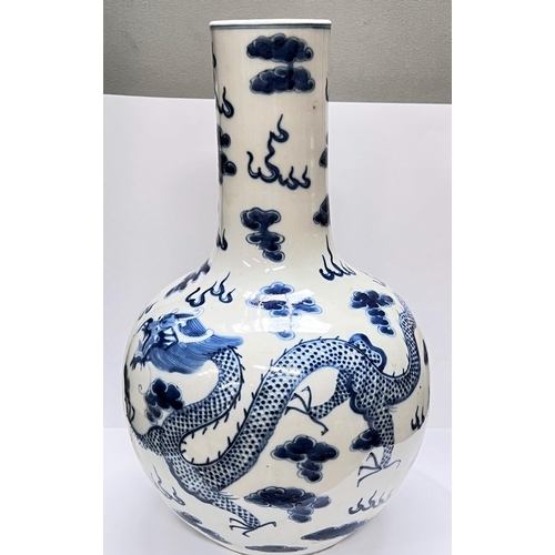 406 - A Chinese blue and white bottle vase decorated with dragons to the body, height 34.5cm, four charact... 