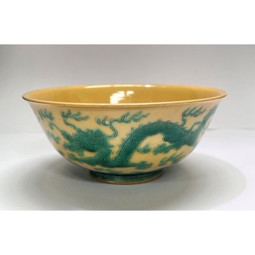 409 - A Chinese yellow bowl with dragon decoration in green to outside of bowl, six character mark to base... 