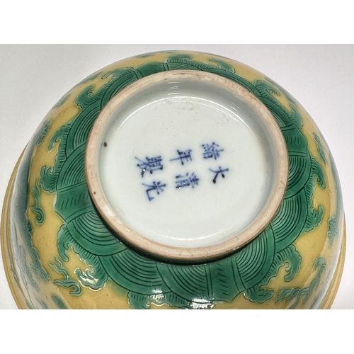 409 - A Chinese yellow bowl with dragon decoration in green to outside of bowl, six character mark to base... 