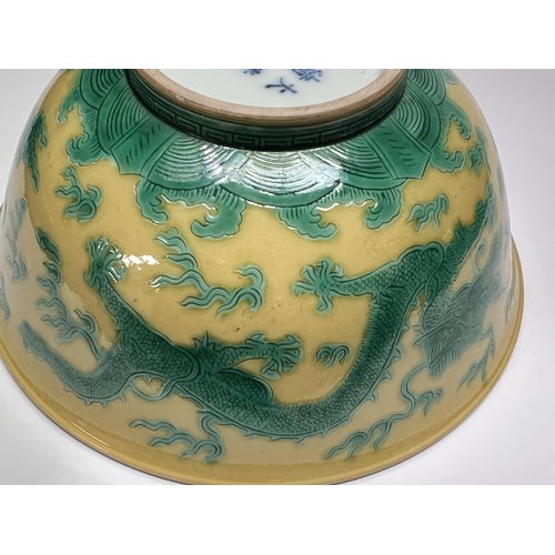 409 - A Chinese yellow bowl with dragon decoration in green to outside of bowl, six character mark to base... 