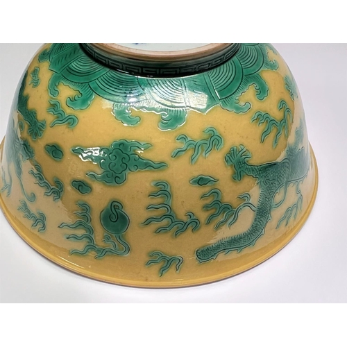 409 - A Chinese yellow bowl with dragon decoration in green to outside of bowl, six character mark to base... 