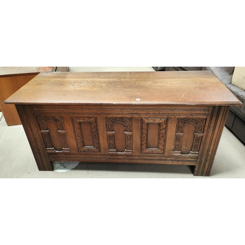 836 - An oak reproduction blanket box with carved panels