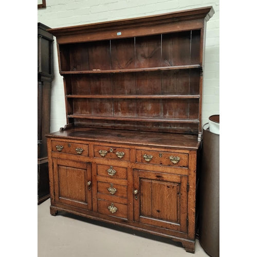 860 - An 18th century Country made Welsh dresser with 3 height delft rack over 3 frieze drawers, 2 side cu... 