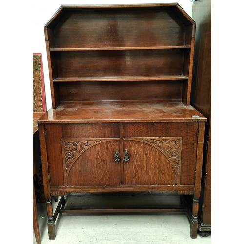 917 - An oak dresser with canted two height shelf back and two cupboards below; a pedestal dinning table a... 