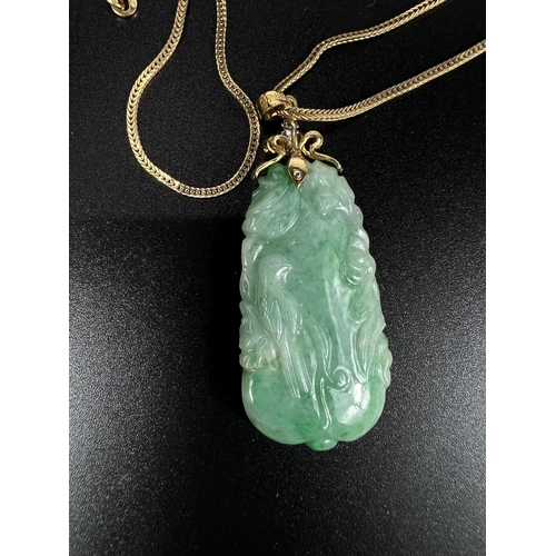 675 - A green jade coloured carved pendant set 4 diamonds, stamped '585 fine', on yellow metal chain stamp... 