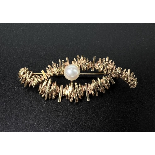 679 - A modernist 9 carat hallmarked gold brooch of elongated form, bark effect and set with a pearl, gros... 