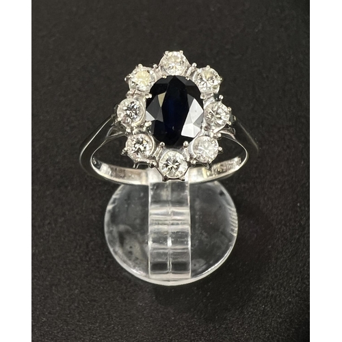 682 - An 18 carat hallmarked white gold dress ring set central oval sapphire, length 7mm, surrounded by 8 ... 