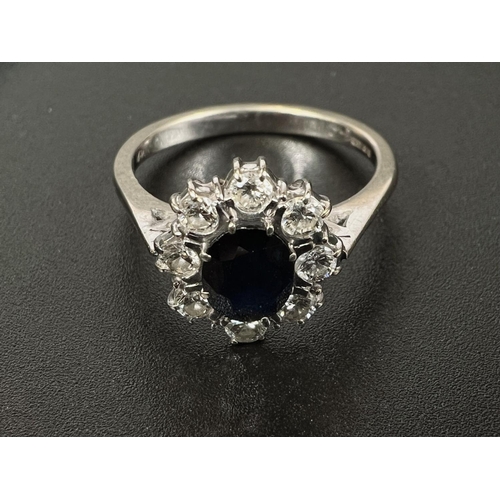 682 - An 18 carat hallmarked white gold dress ring set central oval sapphire, length 7mm, surrounded by 8 ... 